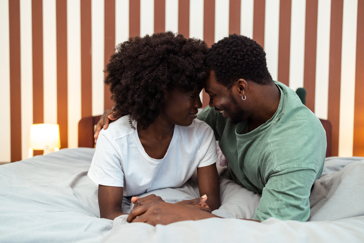 Young African American couple having a romantic moment in bed