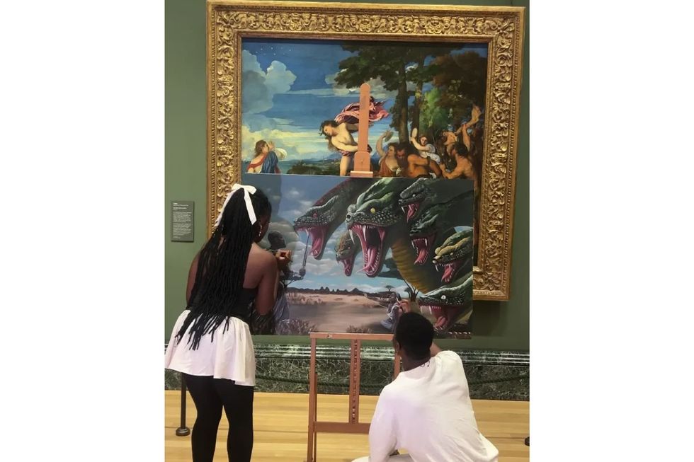 This Creative Couple Is Encouraging People to Read African Mythology Two young artists work on a striking modern painting of a multi-headed serpent attacking warriors, placed on an easel in front of a classical Renaissance artwork in a museum, blending old and new artistic styles in one powerful scene.