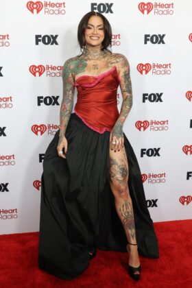 Kehlani stuns in a red satin corset and voluminous Cinderella-style skirt at the 2026 iHeartRadio Music Awards red carpet.