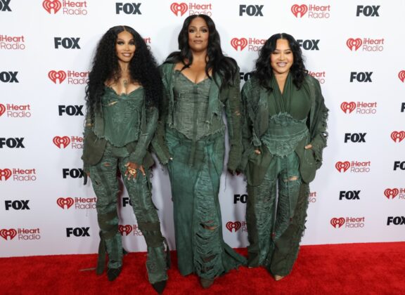 Kehlani stuns in a red satin corset and voluminous Cinderella-style skirt at the 2026 iHeartRadio Music Awards red carpet.
