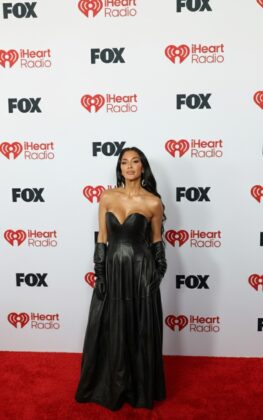 Kehlani stuns in a red satin corset and voluminous Cinderella-style skirt at the 2026 iHeartRadio Music Awards red carpet.
