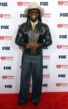Kehlani stuns in a red satin corset and voluminous Cinderella-style skirt at the 2026 iHeartRadio Music Awards red carpet.