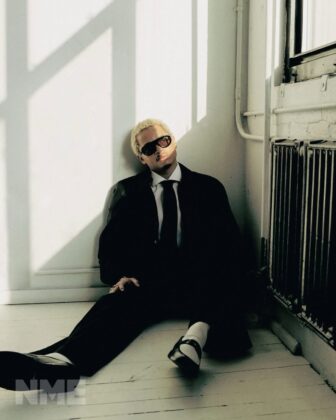 Destin Conrad posing for NME Magazine in a relaxed, high-fashion editorial spread with natural grooming and quiet luxury styling.