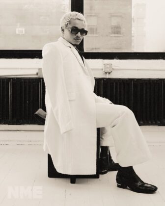 Destin Conrad posing for NME Magazine in a relaxed, high-fashion editorial spread with natural grooming and quiet luxury styling.
