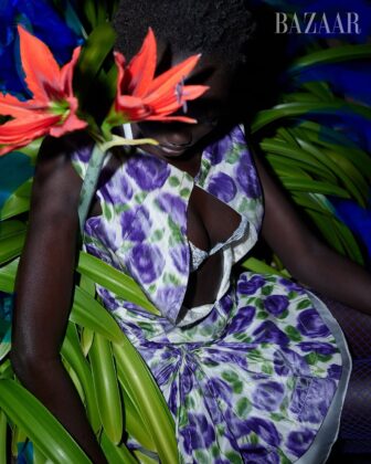 Achol Kuir modeling in the Canary Islands for Harper's Bazaar April 2026, posing against volcanic cliffs in graphic fashion.