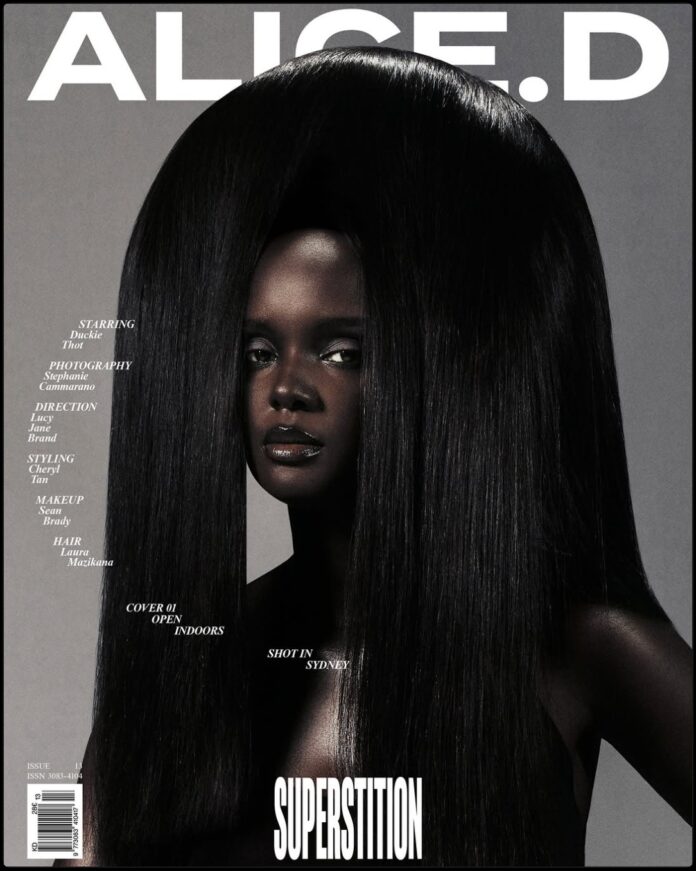 Duckie Thot on Alice’d Magazine May 2026 Cover Duckie Thot on the cover of Alice'd Magazine wearing a bold red top and black skirt, posing confidently against an open city window.