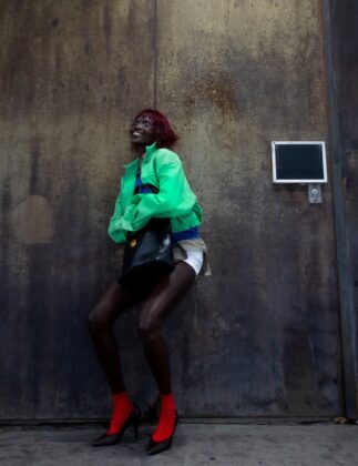 Achok Majak posing in a high-fashion, avant-garde editorial for Flaunt Magazine, featuring bold structural garments and sharp stiletto nails.