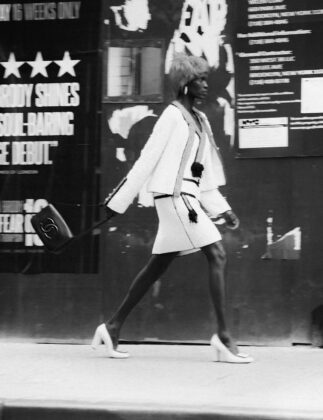 Achok Majak posing in a high-fashion, avant-garde editorial for Flaunt Magazine, featuring bold structural garments and sharp stiletto nails.