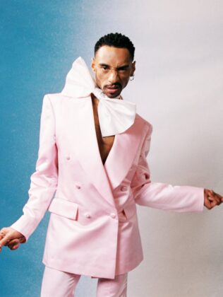 Durand Bernarr posing in a muted lichen green setting with cellular beadwork accessories and textured plumage garments for PAUSE Online June 2026 cover.