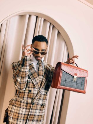 Durand Bernarr posing in a muted lichen green setting with cellular beadwork accessories and textured plumage garments for PAUSE Online June 2026 cover.