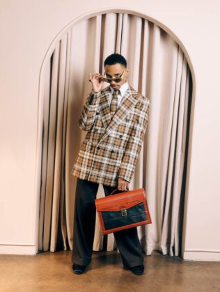 Durand Bernarr posing in a muted lichen green setting with cellular beadwork accessories and textured plumage garments for PAUSE Online June 2026 cover.